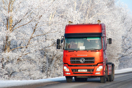 Bashkortostan, Russia - January 4, 2012: Chinese semitrailer truck DongFeng DFL4251 at the background of the snow covered forest.のeditorial素材