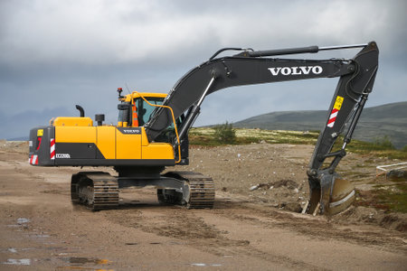 Murmansk Region, Russia - August 17, 2020: Yellow excavator Volvo EC220DL at the gravel road.