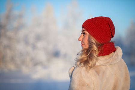Portrait of the young woman in a warm knitted hat and a snood in the winter forestの写真素材