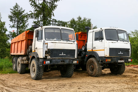 Novyy Urengoy, Russia - July 21, 2021: Offroad dump trucks MAZ-6517 in a city street.のeditorial素材