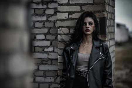 Depressive young woman with bruises in the abandoned brick building