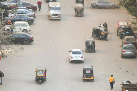 Giza, Egypt - January 26, 2021: View of the city street full of cars and auto rickshaws covered with smoke and dust.のeditorial素材