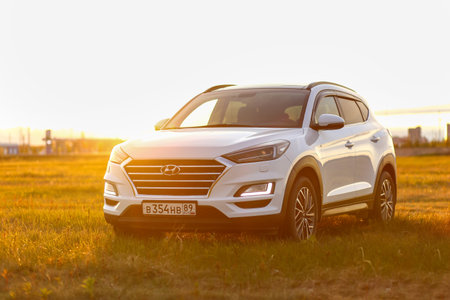 Novyy Urengoy, Russia - June 20, 2023: White urban crossover Hyundai Tucson (TL) in a field at the background of a sunset.のeditorial素材