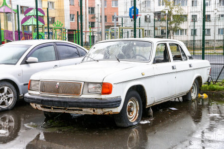 Nadym, Russia - September 4, 2022: Broken and abandoned luxury car GAZ-31029 Volga in the city street.のeditorial素材