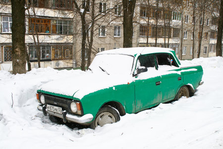 Ufa, Russia - February 16, 2010: Abandoned and covered with snow green Soviet car Izh-Moskvich-412IE-028 in the city street.のeditorial素材