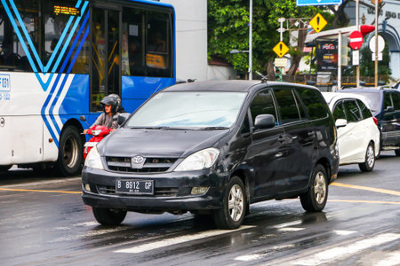 Jakarta, Indonesia - February 16, 2025: Black mid-size van Toyota Kijang Innova (AN40) in the city...