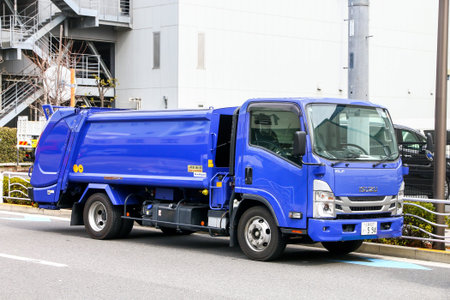 Tokyo, Japan - February 27, 2026: Urban garbage truck Isuzu Elf at the city street.