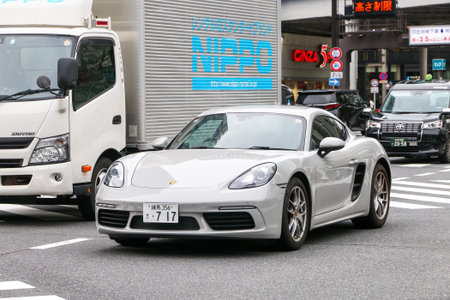 Tokyo, Japan - February 27, 2026: Grey sports car Porsche 718 Cayman (982) at the city street.