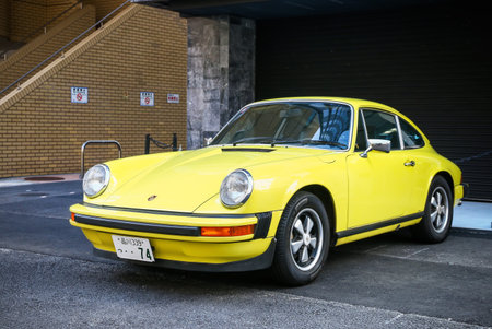 Tokyo, Japan - February 28, 2026: Yellow classic sports car Porsche 911 (930) at the city street.