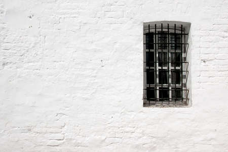 White old brick wall and window with bars  , with space for text or image 