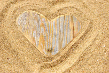 Vintage Wooden Love Heart in the Sand  Summer Marine Background with space for text or imageの写真素材