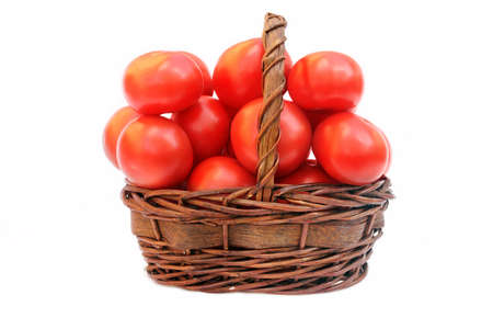 Large tomatoes in the basket isolated on white backgroundの写真素材