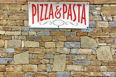Italian Food Sign on Old Stone Wall Backgroundの写真素材
