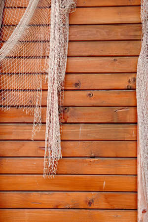 Hanging Fishnet on Wood Wall Backgroundの写真素材