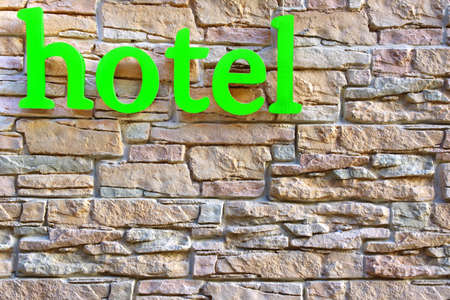 Hotel Sign on Stone Tiled Wall Backgroundの写真素材
