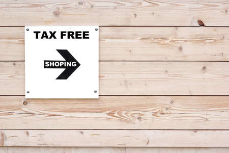 TAX FREE SHOPPING Black White Sign on Whiteboard. Timber White Wall in Background