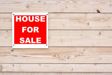 HOUSE FOR SALE Red White Sign on Timber Wall Backgroundの写真素材