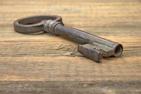 Old Rusty Iron Key on a Wooden Backgroundの写真素材