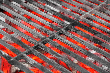 Empty Black Cast Iron Grill and Hot Red Glowing Coals. Background with space for text or image.の写真素材