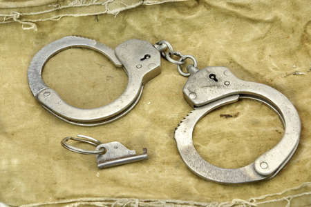 Handcuffs with Key On The  Camouflage Army  Bag or Fabric Backgrond or Texture