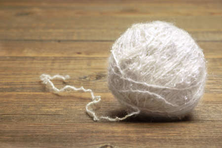 Natural Textured White Single Sheep Wool Roll or Ball or Tangle Closeup On Rustic Wood Table or...