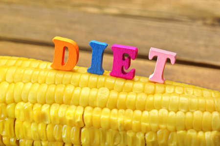 Wooden Sign Diet On Fresh Sweet Corn Close-up. Rough Wooden Board On The Backgroundの写真素材