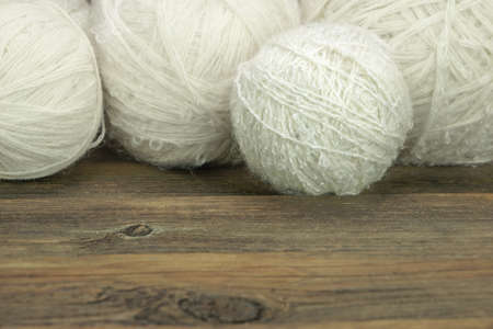 Natural Textured White Wool Rolls or Balls or Tangles Closeup On Rustic Wood Table or Board or Floor  Backgroundの写真素材