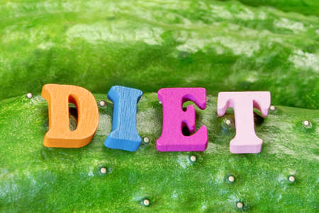 Wooden Sign DIET On Fresh Home Grown Cucumbers Close-up Green Background