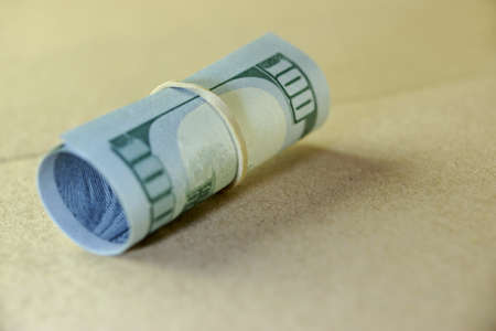Money Roll With US New One Hundred Dollar Bill Close-up On The Beige Floor Background.  Selective...