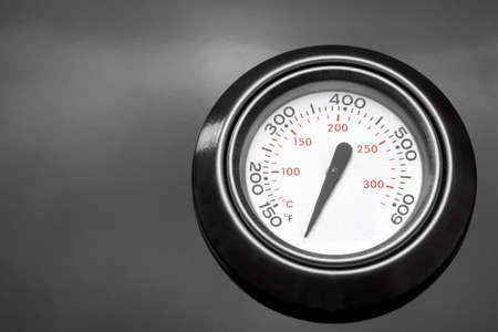 BBQ Grill Thermometer Close-up On The Black Iron Cover Background