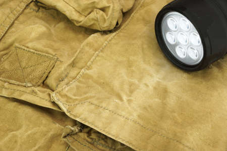 Turned On Led Tourchlight On The Faded Green Backpack Background Close-upの写真素材