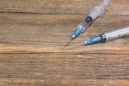Two Small Empty Disposable Syringe On Wood Rough Background With Copy Spaceの写真素材