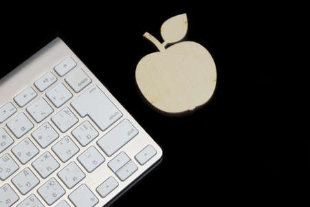 Wireless Slim wireless Keyboard And Wooden  Apple Sli%u0441e Isolated On Black Glass Background With Reflectionの写真素材