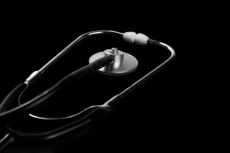 Close-up Of Modern Acoustic Stethoscope Isolated On Black Background In Dark Light With Copy Spaceの写真素材