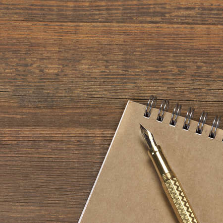 Notepad With Real 24k Gold Fountain Pen On The Old Rough Wooden Table Backgroundの写真素材