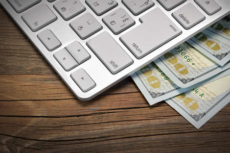 Computer Keyboard  And Dollar Cash On The Rough Wood Background. E-commerce Or Freelance Work...