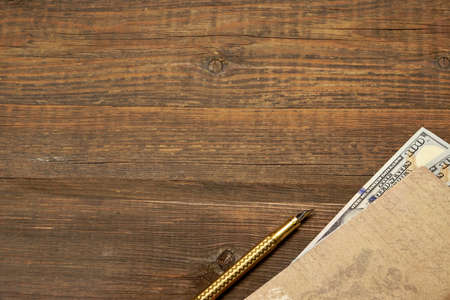 Vintage Notebook With Nested Money And Golden Fountain Pen Are In The Corner Of Rough Wood Rustic Background With Copy Space,   Business And Finance Conceptの写真素材