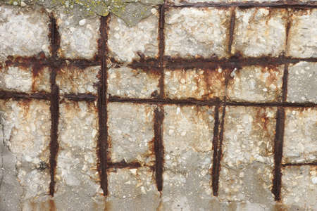 Fragment of a concrete wall with a rusty wire mesh background texture