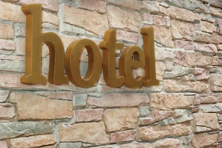 Hotel Sign On Artificial Stone Wall Background. Vacation Conceptの写真素材
