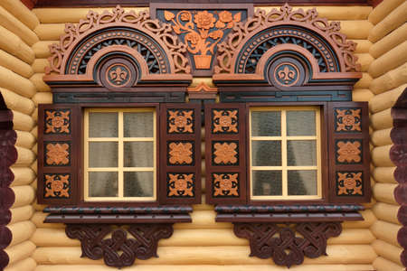 Yellow Log Cabin Wall With Two Ornamental Windows,  Wooden Architecture Backgroundの写真素材