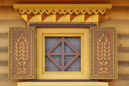Yellow Log Cabin Wall With One Ornamental Window,  Wooden Architecture Backgroundの写真素材