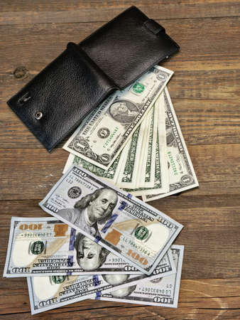 High Angle View Of Modern Black leather Men's Wallet With Dollar Cash On The Old Rough Wood Textured...