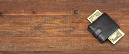 High Angle View Of Modern Black leather Men's Wallet With Dollar Cash On The Old Rough Wood Textured Background With Copy Spaceの写真素材