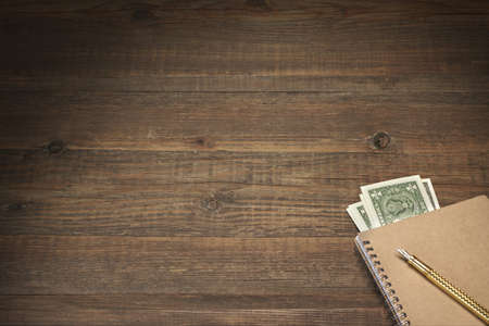 Overhead View On The Rustic Rough Brown Wood Table With USA Dollar Cash Nested In The Pocketbook And Real Gold Ink Pen, Business Or Home Finance Concept  And Background With Copy Spaceの写真素材