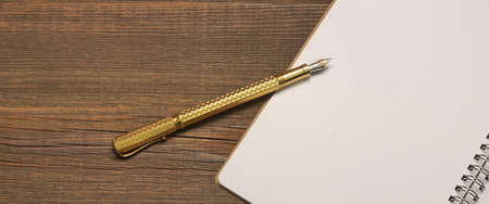Top View On The Rustic Rough Brown Wood Table Brown Wood Table With Opened Notebook With  Blank WhitePage And Real Gold Fountain Pen, Business Or Home Finance Concept  And Background With Copy Spaceの写真素材