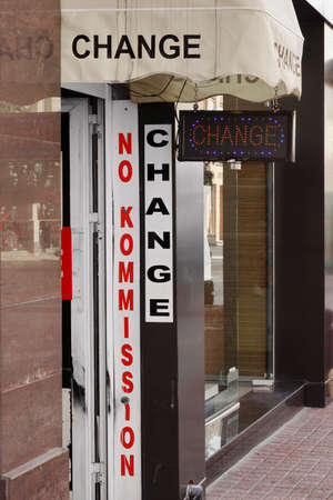 Foreign Currency Exchange Office On The City Street With Advertising Information On The Door And...
