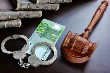 Judges Gavel, Handcuffs, Euro Cash And Old Law Book  On The Black Wooden Table Background In The Back Light. Overhead View.の写真素材