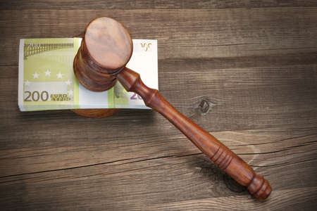 Concept For Corruption, Bankruptcy Court, Bail, Crime, Bribing, Fraud, Auction Bidding. Judges or Auctioneer Gavel And Bundle Of Euro Cash On The Rough Wooden Textured Table Background. Top Viewの写真素材
