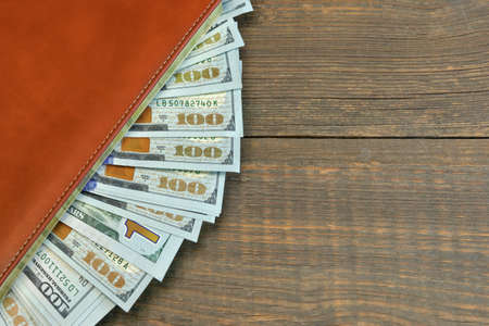 American One Hundred Dollar Bills In The  Notepad Top View On The Rough Wooden Table Background With...