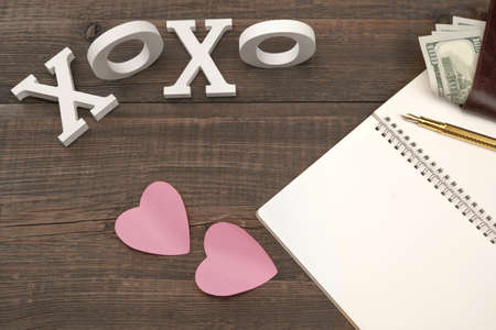 Love Kiss Concept. Sign XOXO, Two Paper Pink Sticker Hearts, Gold Pen, Blank Page, Male Wallet With...